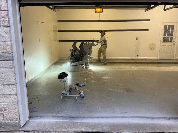 Cracked, stained bare concrete garage floor before coating